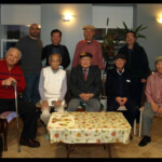 Superintendent Tony (left, rear) meets in the first floor lounge with a group of happy tenants.